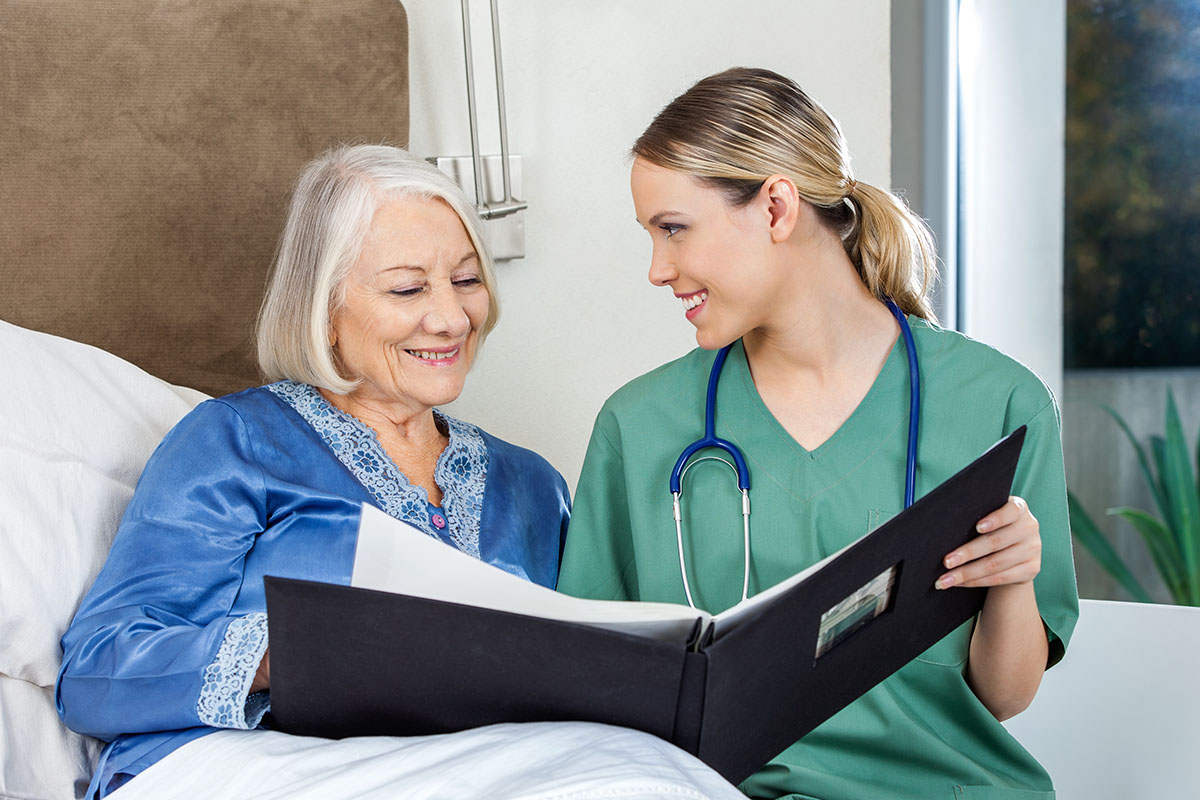 Jasmine Estates of Oklahoma City | Caregiver Showing Medical Reports To Senior Woman | How to Know When It's Time for Memory Care: A Guide for Families